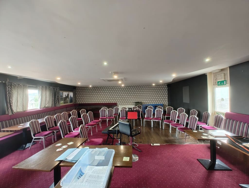The function room from the far end, banquette seating running down both sides