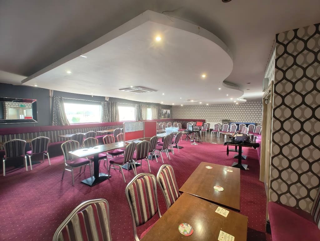 Tables and chairs across the function room floor, windows down one side