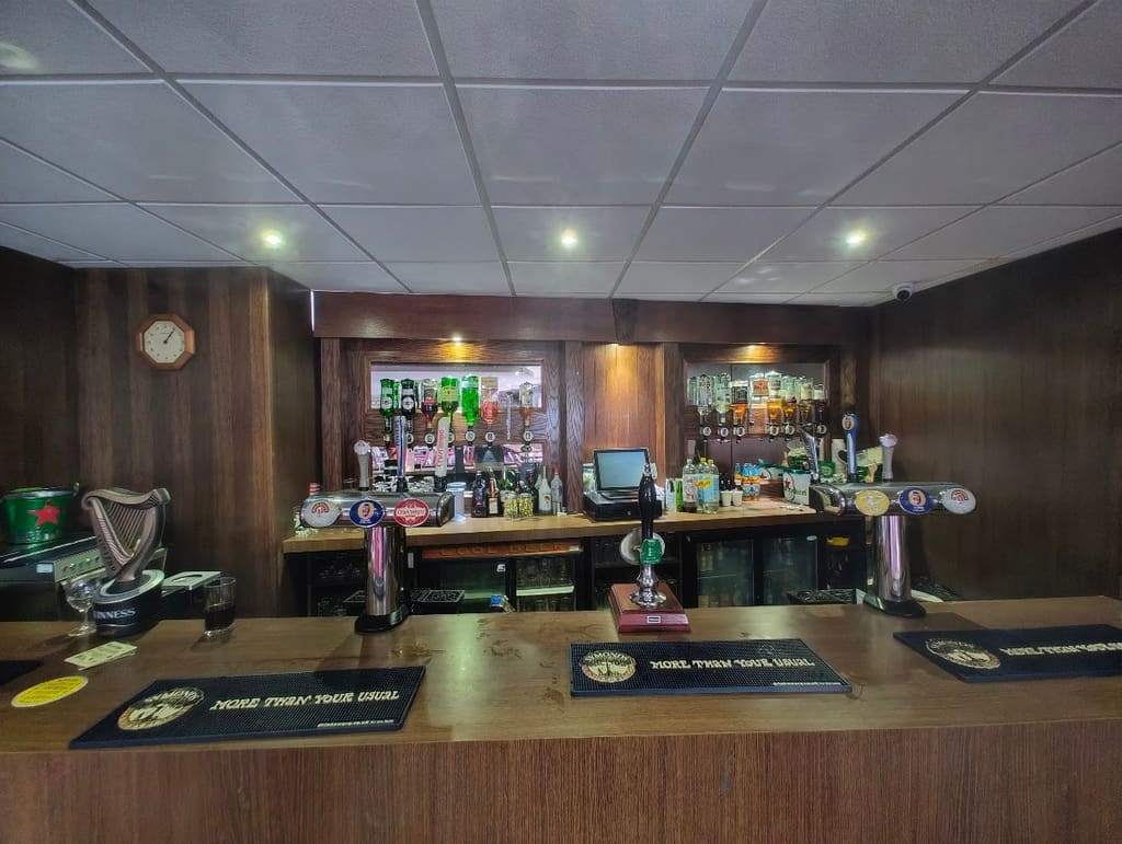 The bar inside the function room, with draught pumps and a mirrored back wall