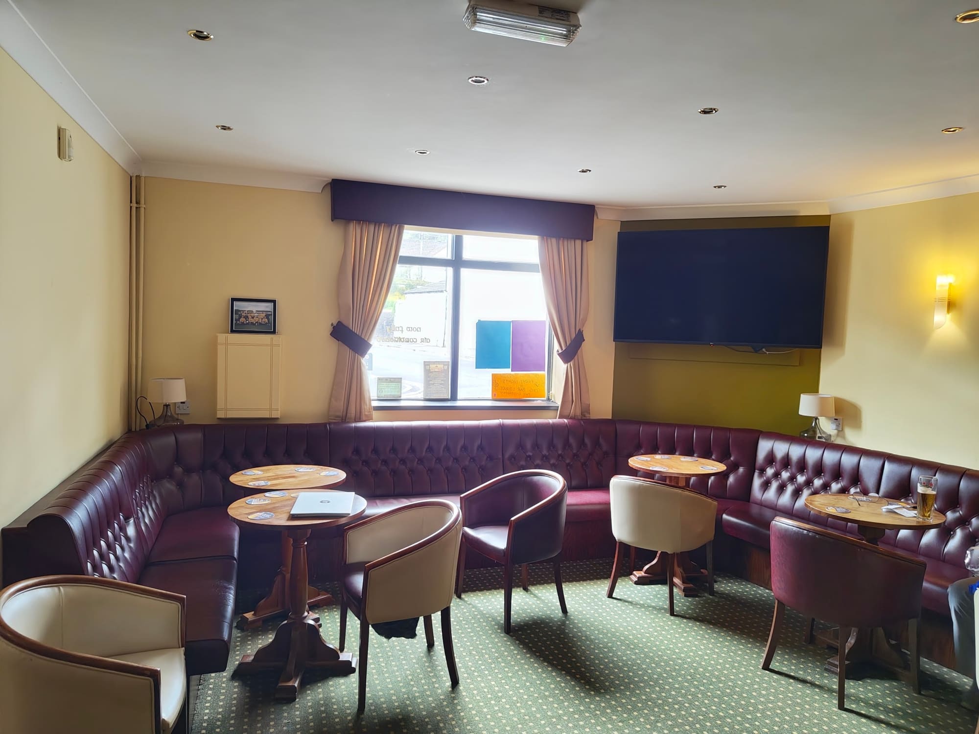 The lounge, with buttoned leather banquettes around the walls and low round tables