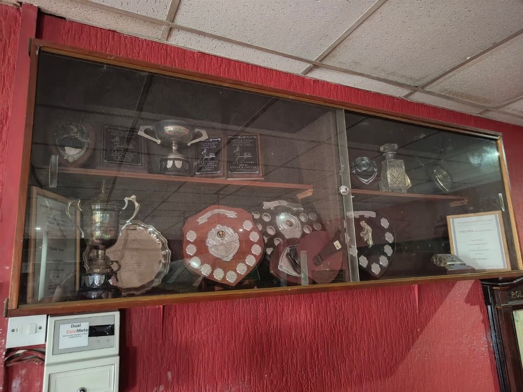 A glazed cabinet of cups, salvers and shields won by the club’s teams